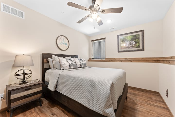 Slaapkamer op de onderste verdieping met een queensize bed.