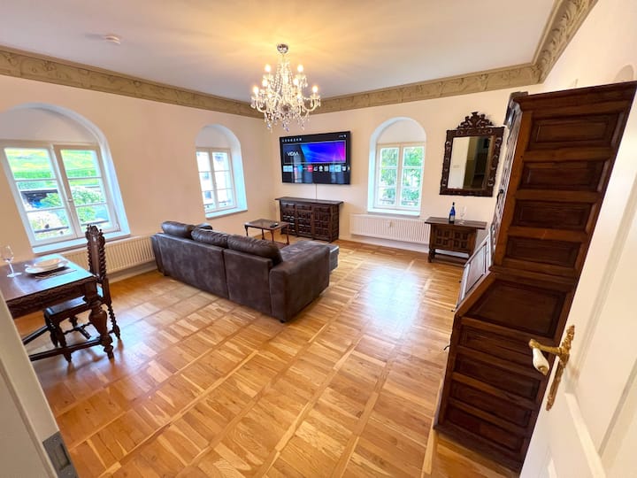 منطقة معيشة مع سرير أريكة وتلفزيون ذكي 75بوصة