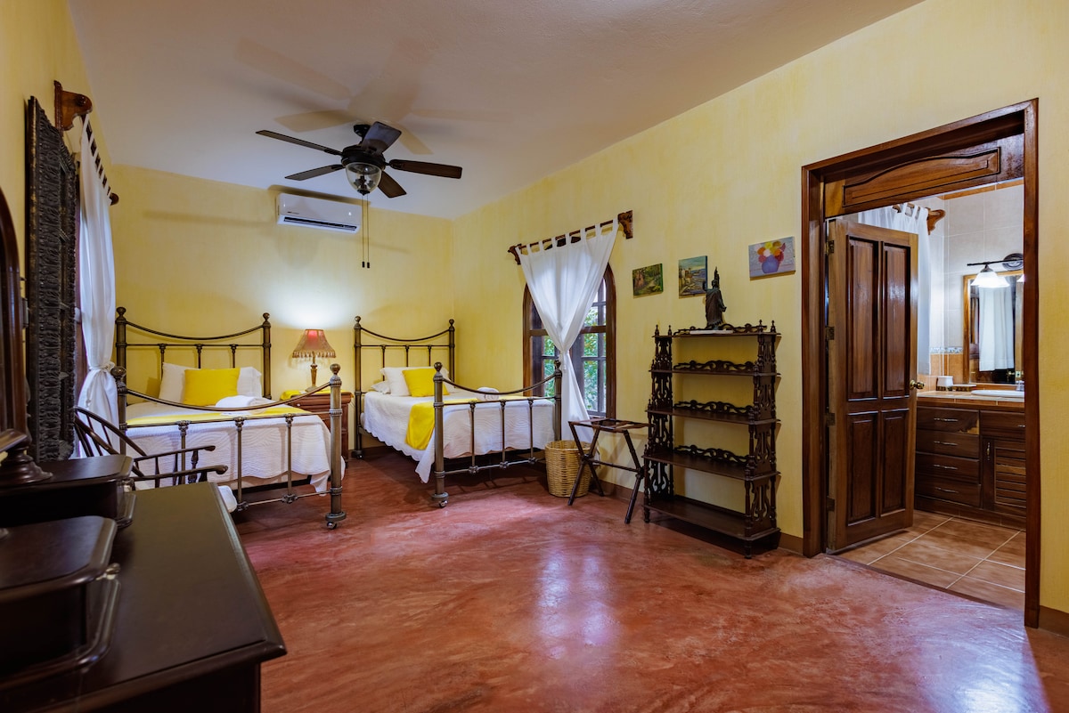 Kjo dhomë, e vendosur në katin e poshtëm të shtëpisë, ka dy krevate dopio, ajër të kondicionuar, një ventilator tavani, një dollap dhe një banjë brenda. Ofron një pamje të këndshme të zonës së kopshtit, duke i shtuar një ndjesi qetësie qëndrimit tënd.