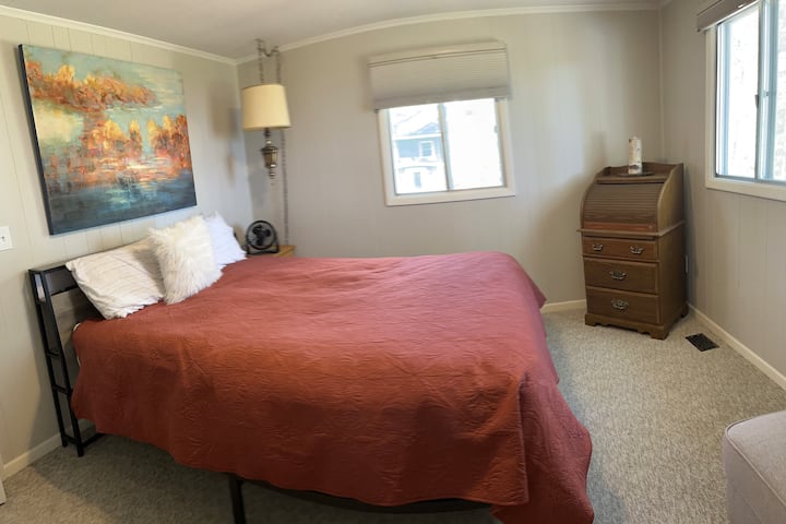 Spálňa 1: menšia manželská posteľ, televízor Roku, nočné svetlo, stropné svetlo a polovičná kúpeľňa.