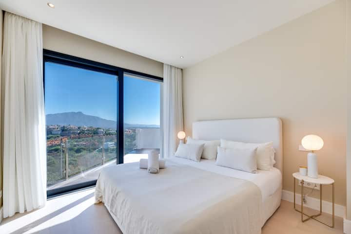 Тази спалня предлага панорамна гледка към планината за спокойно начало на деня ви.