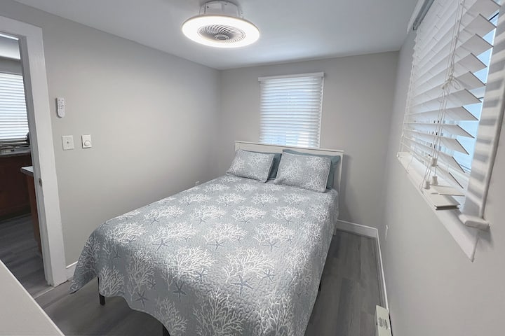 The 1st bedroom or front bedroom of this family vacation rental features a queen bed, linens, and dresser for personal items. The bed is high enough to slide your suitcases underneath for easy storage.  No closet available in this room.
