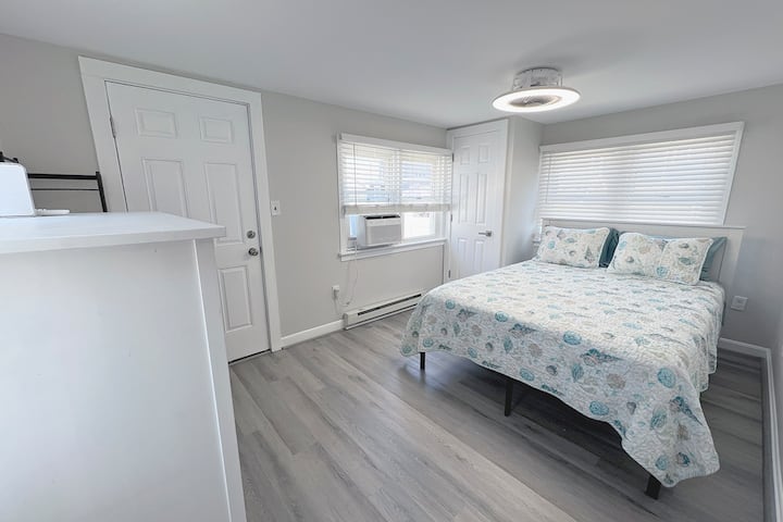 The 3rd bedroom or back bedroom of this family vacation rental features a queen bed, dresser, linens, and shelf rack for personal items. The bed is high enough to slide your suitcases underneath for easy storage. The closet is not available here.