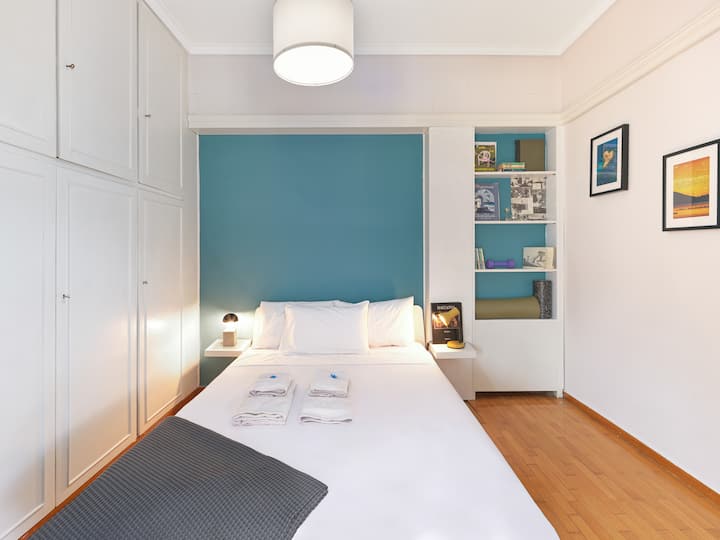 Un dormitorio sereno con una pared azul relajante, sábanas suaves y detalles cuidados para una noche de sueño reparador