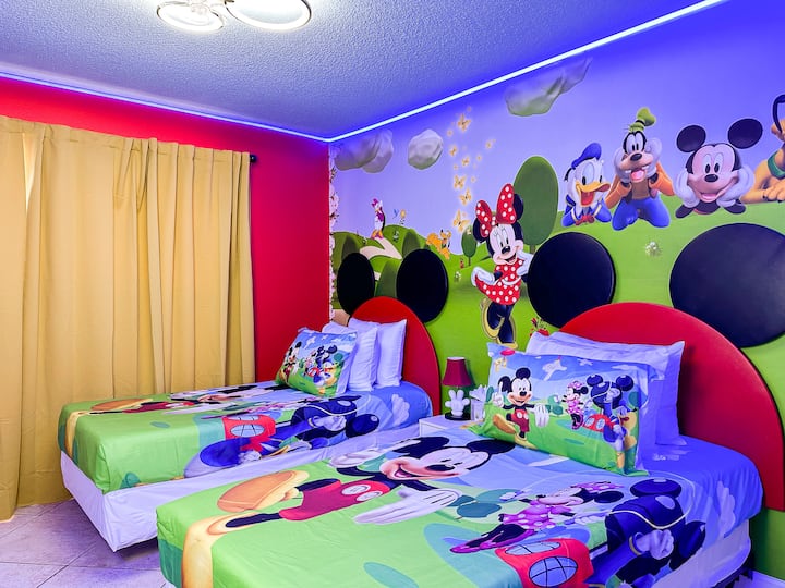 Entra en el país de las maravillas de Mickey: vibrantes murales verdes de Mickey y sus amigos envuelven las camas individuales cubiertas con clásicos amigos de peluche. Las cortinas rojas y amarillas enmarcan la habitación, mientras que los adornos LED brillantes y las calcomanías de pared caprichosas aportan la magia de Disney a cada noche de ensueño.