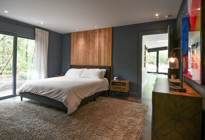 ห้องมาสเตอร์สวีทระดับหลักเป็นสถานที่พักผ่อนส่วนตัวที่มีห้องน้ำในตัว ประตูกระจกบานเลื่อนตรงไปยังระเบียงด้านนอกผสมผสานความสะดวกสบายในร่มกับการพักผ่อนกลางแจ้ง