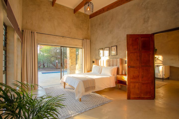 Grote en luxe tweede slaapkamer met airconditioning met elektronische kluis, ruime kastruimte, luxe queensize beddengoed en eigen badkamer met regendouche die opengaat naar privézwembad en patio.