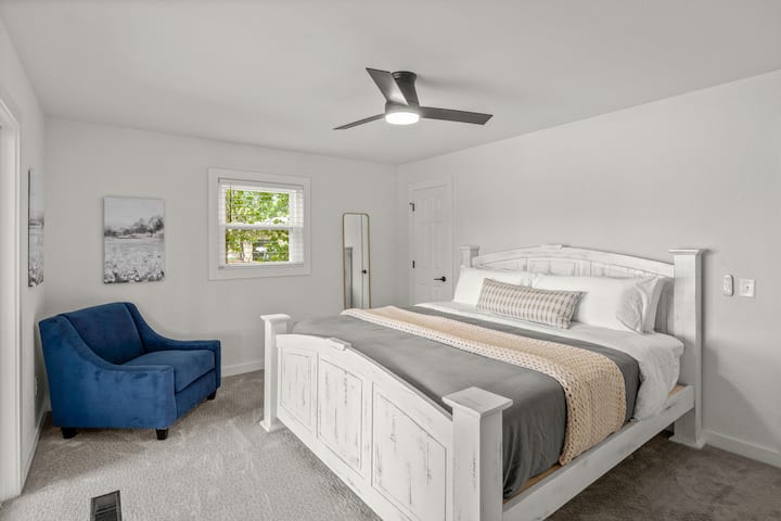 King size bedroom with cozy blue chair and amazing sliding door views of the lake!