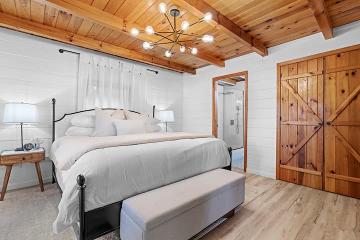 Main floor primary suite features a king bed, dresser, closet, and ensuite bathroom.