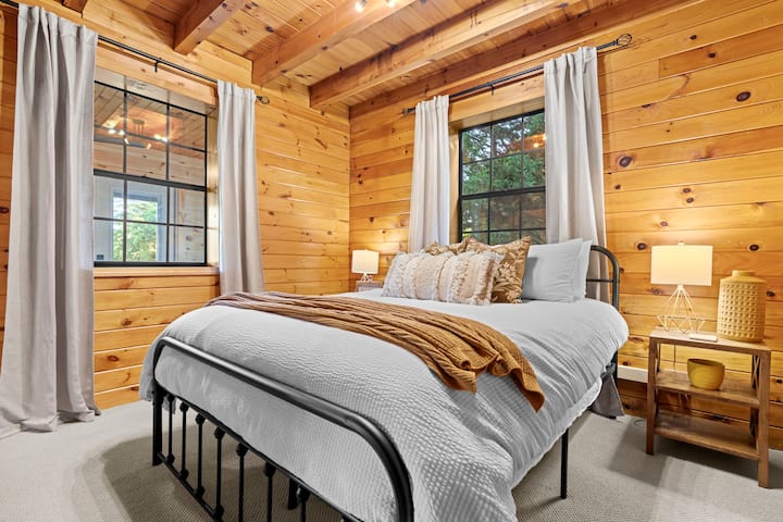 This downstairs bedroom features a queen sized bed, clothing storage, and a closet. 