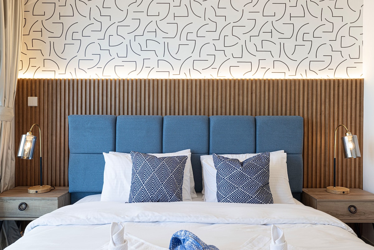 انغمس في الفخامة مع غرفة نوم مصممة بشكل جميل لا توفر الراحة فحسب، بل توفر أيضًا إطلالات خلابة على البحر وأفق المدينة