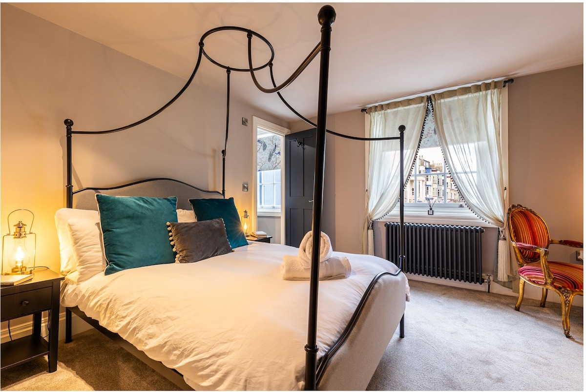 חדר שינה שני מעוצב להפליא עם חדר רחצה צמוד, נוף מקסים מאחור על הגנים היפים