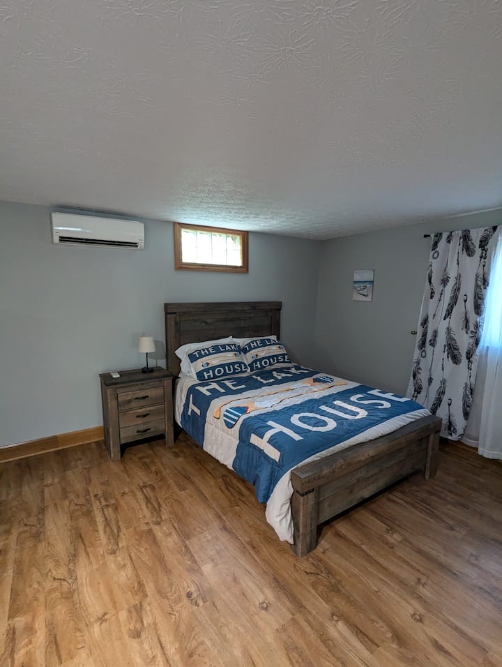 A view of the bed in the downstairs studio apartment. Privacy barriers are included with the home that you can put up if you'd like to have more than one sleeping area downstairs. Downstairs is a studio apartment with full bath, kitchen, and living