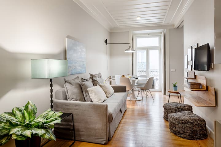 غرفة معيشة مع أريكة مريحة وتلفزيون وطاولة طعام.