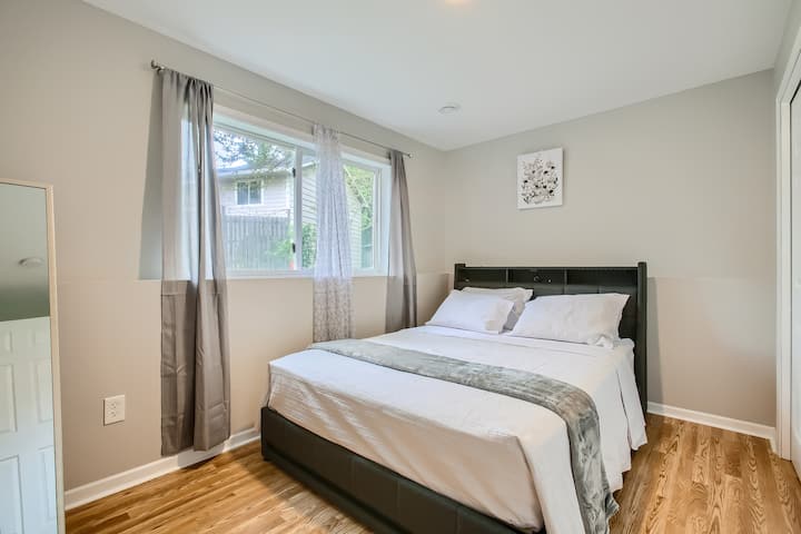 Spavaća soba s parketom i udobnim bračnim krevetom.