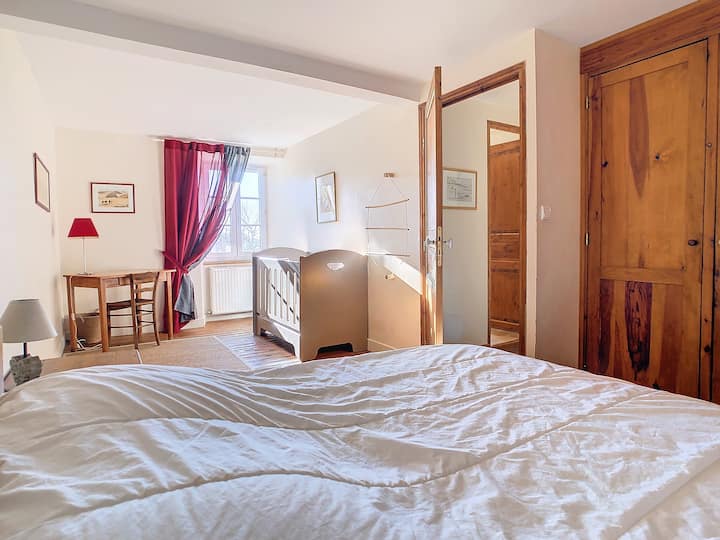 Gran habitación con cuna y espacio de oficina