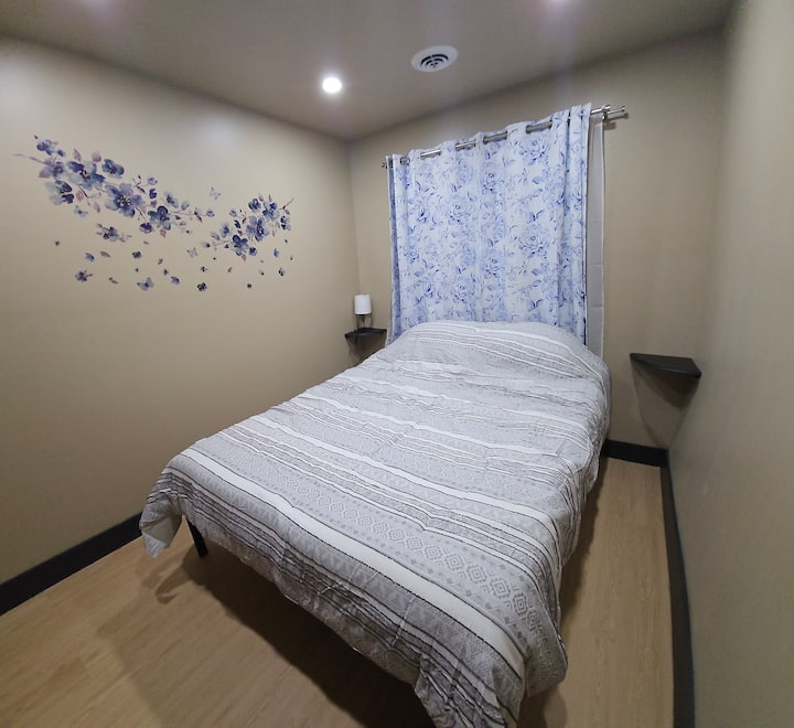 Relájate en el dormitorio 1, con una cama tamaño queen con un cómodo colchón de espuma viscoelástica. Disfruta de un soporte de contorno personalizado patentado sin fibra de vidrio y una espuma base resistente. La habitación incluye un armario con estantes y perchas para tu comodidad.