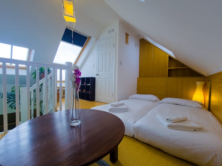 日式卧室，日式榻榻米上有两张单人床垫