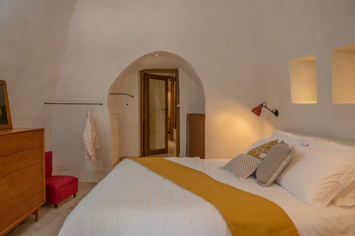 Dormitorio en Villa Acquamarina, con una almohada suave y una chaqueta a cuadros, creando un ambiente cálido y acogedor.