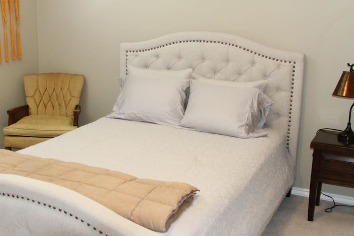 ห้องนอนที่อบอุ่นนี้ตั้งอยู่บนชั้นหลักของบ้านและสามารถเข้าถึงได้โดยไม่ต้องใช้บันได  มีเตียงควีนไซส์และพื้นที่ตู้เสื้อผ้าขนาดใหญ่