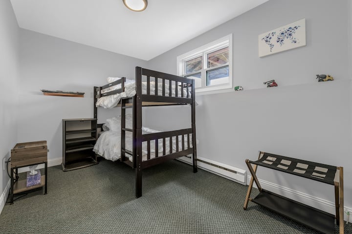 Twin bunk beds with a side table with charging ports for electronics