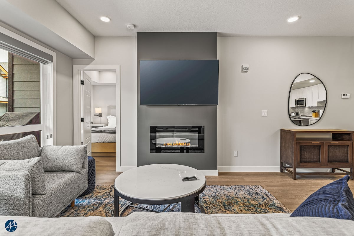 The Owl's Nest Canmore-area condo — Living room with electric fireplace