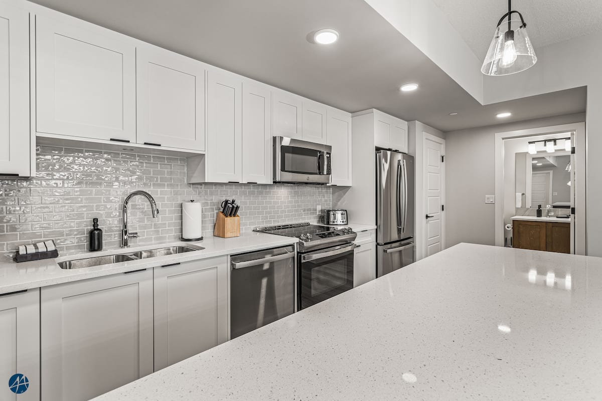 Fully stocked kitchen with quartz island and gas stove — 3 bedroom Canmore condo rental