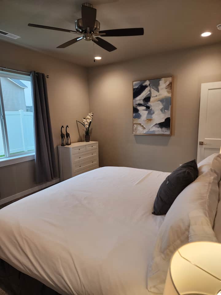 Hoofdslaapkamer met kingsize bed, smart-tv, plafondventilator en eigen badkamer met dubbele lavabo en inloopkast. 