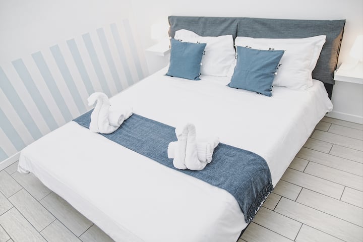 חדר השינה המשני עשוי להיות קצת יותר קטן, אבל הוא מצויד בקפידה עם שולחן ליד המיטה ומנורות לקריאה הלילית שלכם.