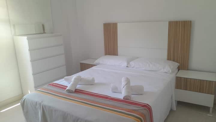 glavna spavaća soba s bračnim krevetom i pogledom na urbanizaciju bazena i teniskog terena