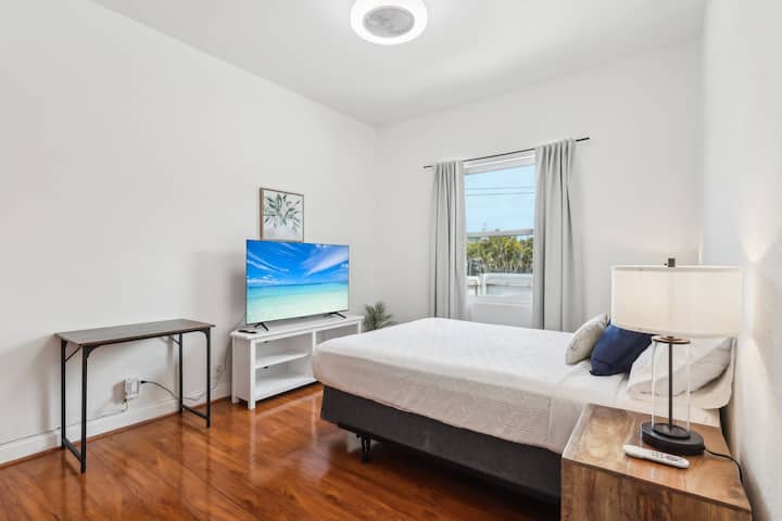 Bedroom 3 is a charming, light-filled retreat with a cozy queen-size bed, blackout curtains for added privacy, and a TV for your entertainment, making it the perfect spot to unwind and relax.