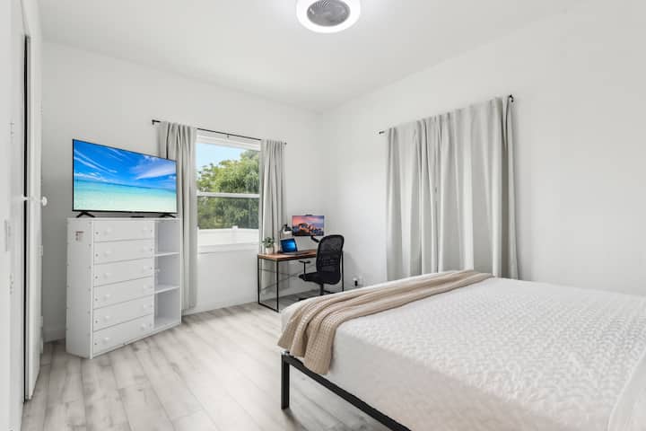 Comfortable Bedroom 2 featuring a king-size bed, a dedicated workspace with a monitor, and a TV, perfect for those who need to catch up on work or relax while enjoying their vacation. It also includes a huge closet for ample storage.