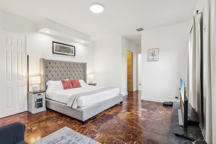 Spacious master bedroom featuring a luxurious king-size bed for ultimate comfort and relaxation, recessed lighting for a soft, ambient glow, and blackout curtains to ensure a peaceful and restful sleep.