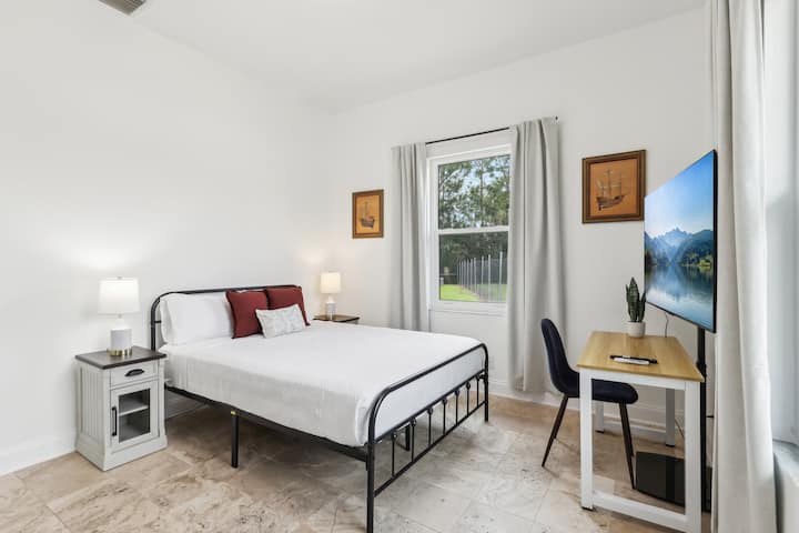 Bedroom 4 is filled with natural light and features a comfortable queen-size bed, creating a warm and welcoming atmosphere.