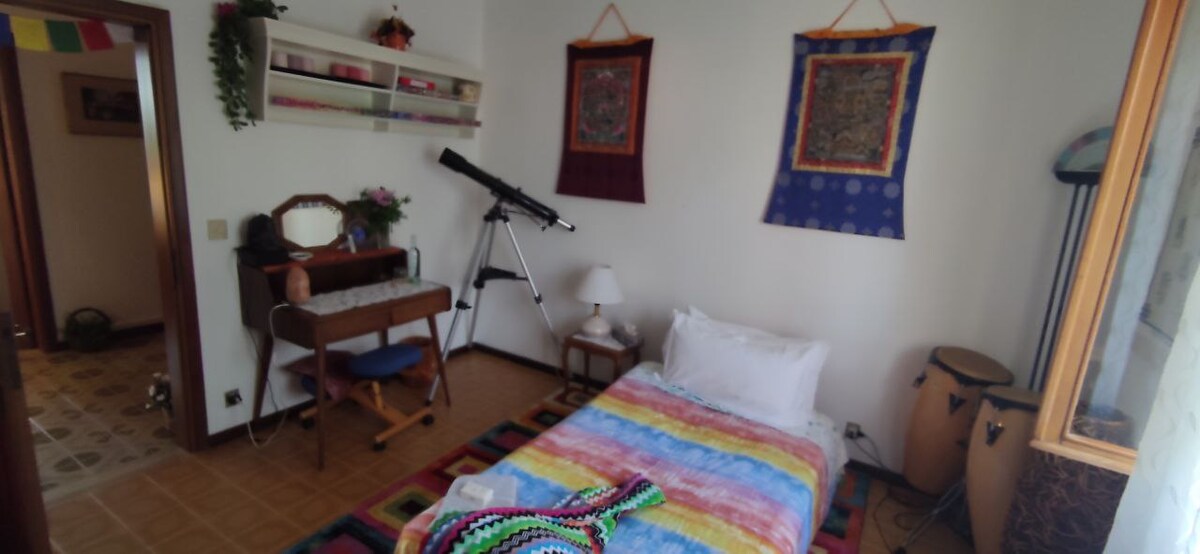 ruimte voor holistisch gebruik (massages, muziekinstrumenten, gezondheids- en welzijnsthema 's) waarvan de slaapbank geschikt is voor (zoals op deze foto) een persoon. Er is een bureau uit de jaren '40, een ergonomische stoel, een salontafel. Kleerhangers en boekenplankruimte