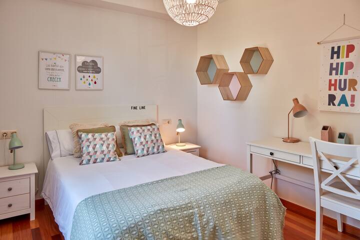 Спална соба со двоен кревет и дополнителна работна маса.