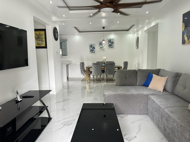 Opustite se u ovom dnevnom boravku u kojem se nalazi sivi kauč, stakleni stolić za kavu i suvremeni dekor te nudi elegantan ambijent idealan za opuštanje ili zabavu.