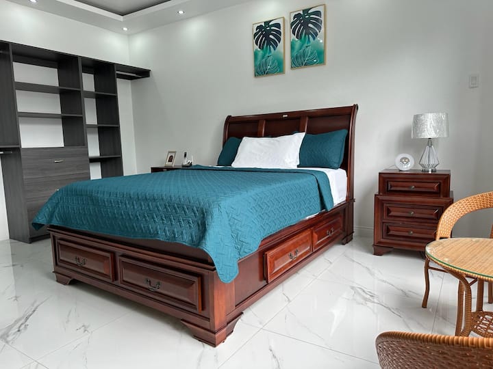 U drugoj spavaćoj sobi nalazi se veliki drveni krevet s ladicama za odlaganje. Soba ima mramorne pločice, noćni ormarić i dvije pletene stolice s malim stolom. Prostorija je osvijetljena ugradbenim stropnim svjetlima.