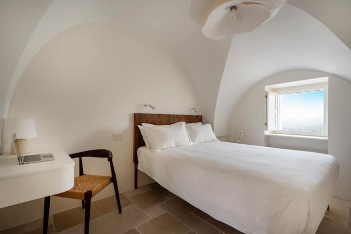 spálňa s manželskou posteľou a klenutým stropom, kamenná podlaha Trani, skriňa s dvojitými dverami, televízor s plochou obrazovkou a Netflixom, písací stôl so stoličkou, kúpeľňa so spálňou