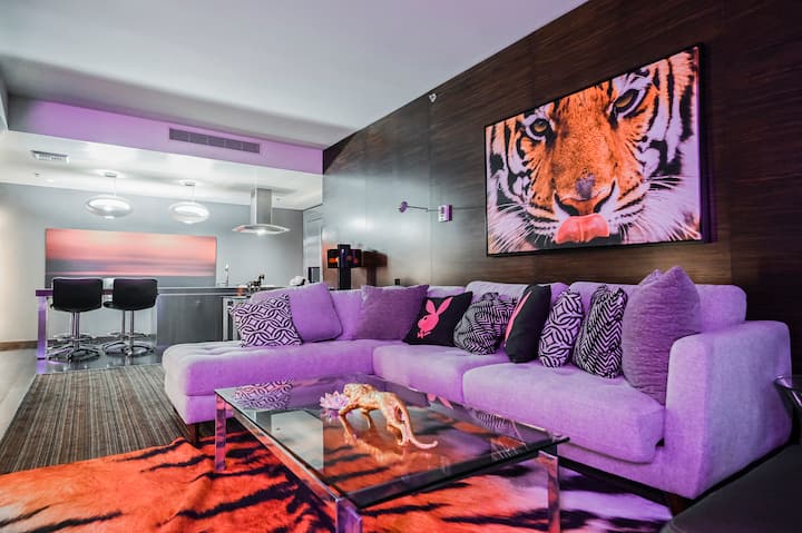 Sala de estar con obra de arte de un tigre y sofá modular morado