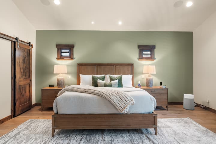 Retreat to the upstairs master suite featuring vaulted ceilings, plush king bed, and stylish modern decor—your luxurious haven in the trees.