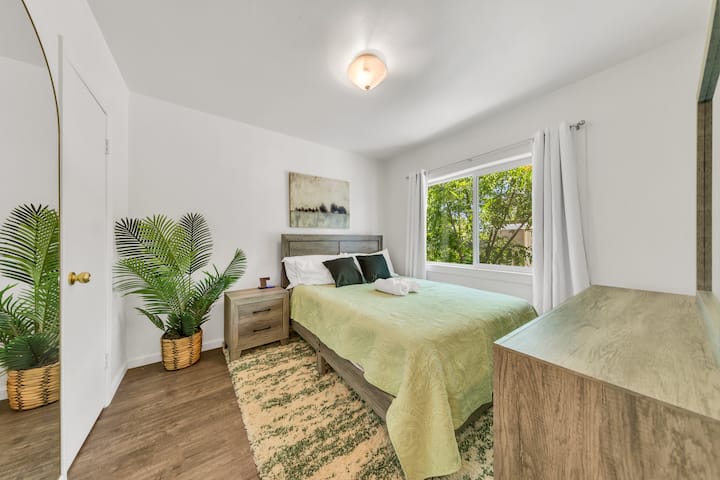 ห้องนอนสว่างและโปร่งสบายพร้อมเตียงขนาดควีนไซส์เต็มไปด้วยแสงธรรมชาติที่สวยงามสำหรับการเข้าพักอย่างสงบ