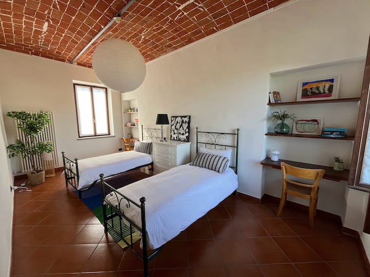 明亮愉快的卧室，配有两张单人床、两张小桌子和一个梳妆台。 走廊有空调，与次卧共用。 可欣赏山谷和村庄的美景。 