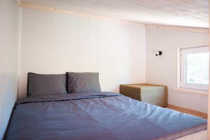 El dormitorio está situado en el segundo piso.  Ten en cuenta que debes usar las escaleras para ello. El futón se pliega en un colchón en el piso.  