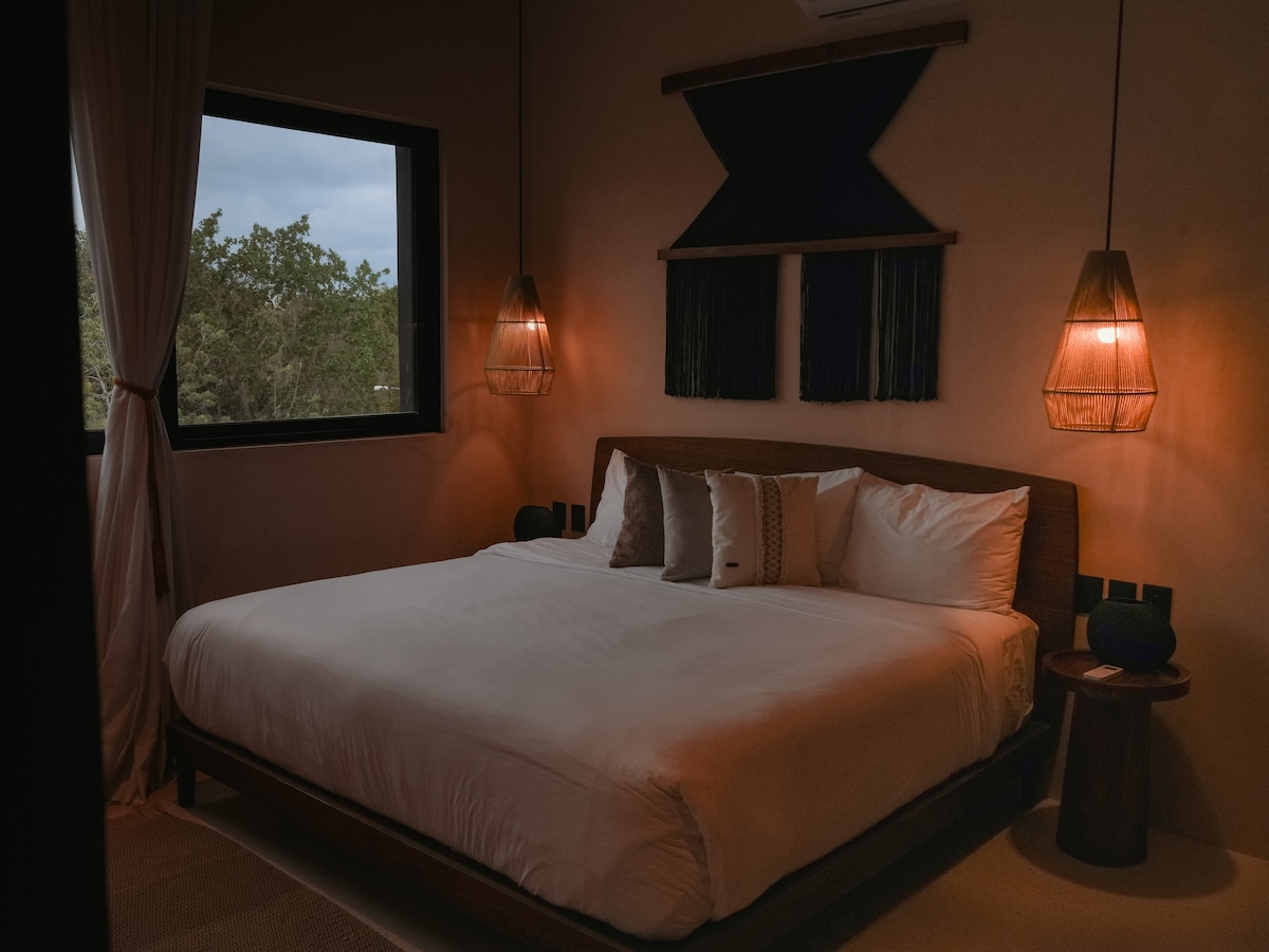 Dormitorio principal con aire acondicionado: descansa cómodamente con ropa de cama lujosa y vistas a la selva.
Baño privado de lujo: baño privado adjunto a la suite principal para mayor comodidad.