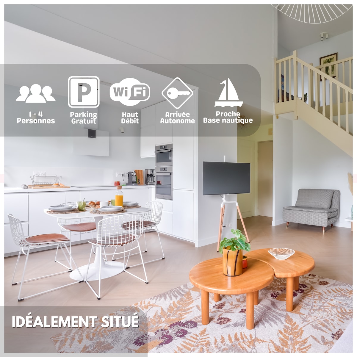 A bright living area features a dining table set for four, complemented by a cozy seating arrangement. A television stands on a stylish stand, while light filters through large windows. The open space connects to the kitchen, equipped with modern appliances.