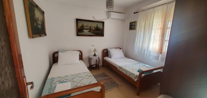 Dhoma 2 ka pamje nga pjesa e përparme e kopshtit, duke ofruar një pushim të qetë dhe të qetë ku tingujt e butë të zogjve rrisin atmosferën e qetë, të përsosur për pushim dhe relaksim.