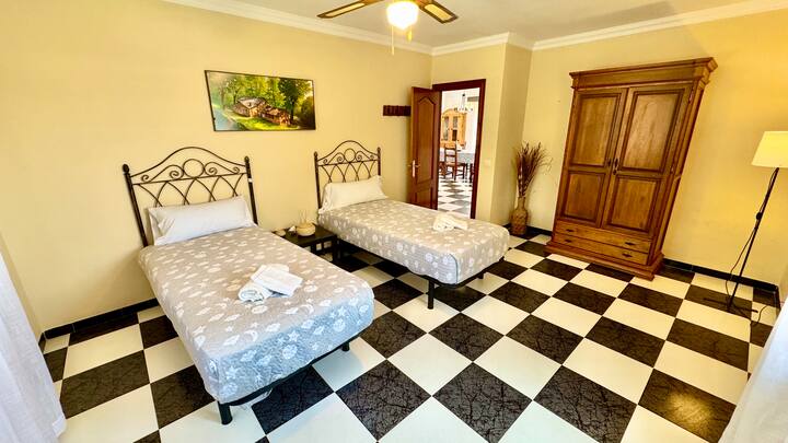 Dormitorio con dos camas individuales, armario y ventilador