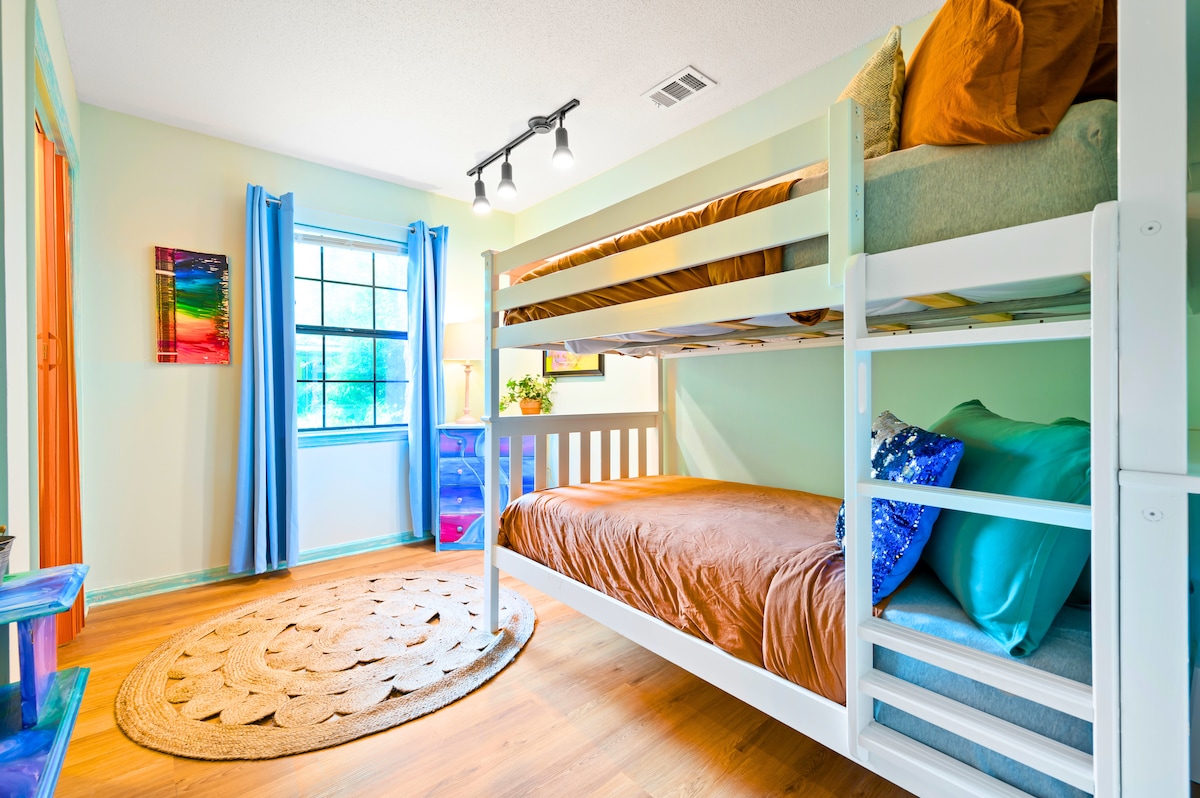 Uhvatite novi kut našeg udobnog kreveta na kat s ljestvama koje se lako mogu popeti. Živopisni okrugli tepih pruža udobnost, a zavjese za zamračivanje jamče miran san. Razigrani mural s bojama na zidu dodaje malo boje i kreativnosti.