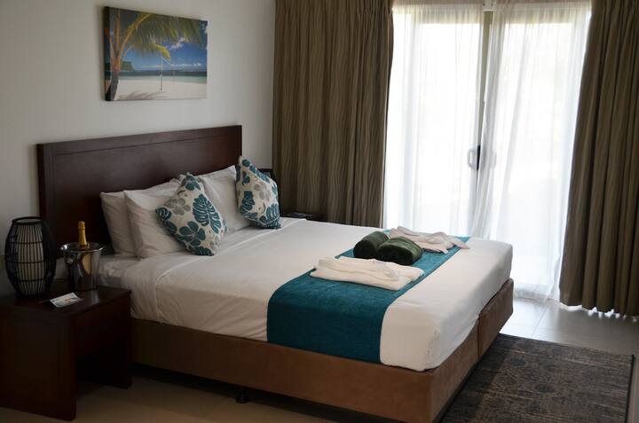 La camera da letto principale dispone di un comodo letto, un bagno privato e una TV per il tuo intrattenimento. Rilassati in questo spazioso rifugio dopo una lunga giornata, con tutti i servizi necessari per un soggiorno riposante e accogliente.